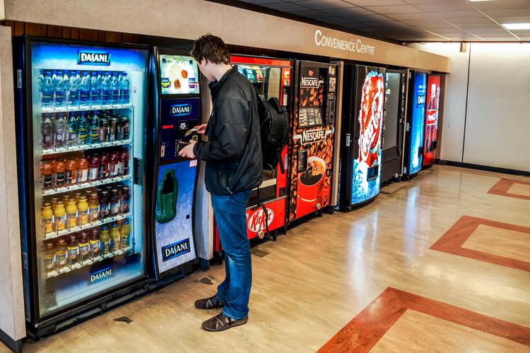 Man ordering a beverage from a vending machine 